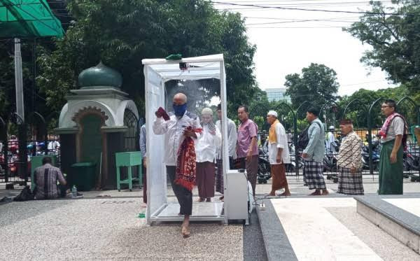 Jemaah memasuki bilik sterilisasi di Masjid Jami’ Kota Malang (Foto: Lalu Theo/ngopibareng.id)