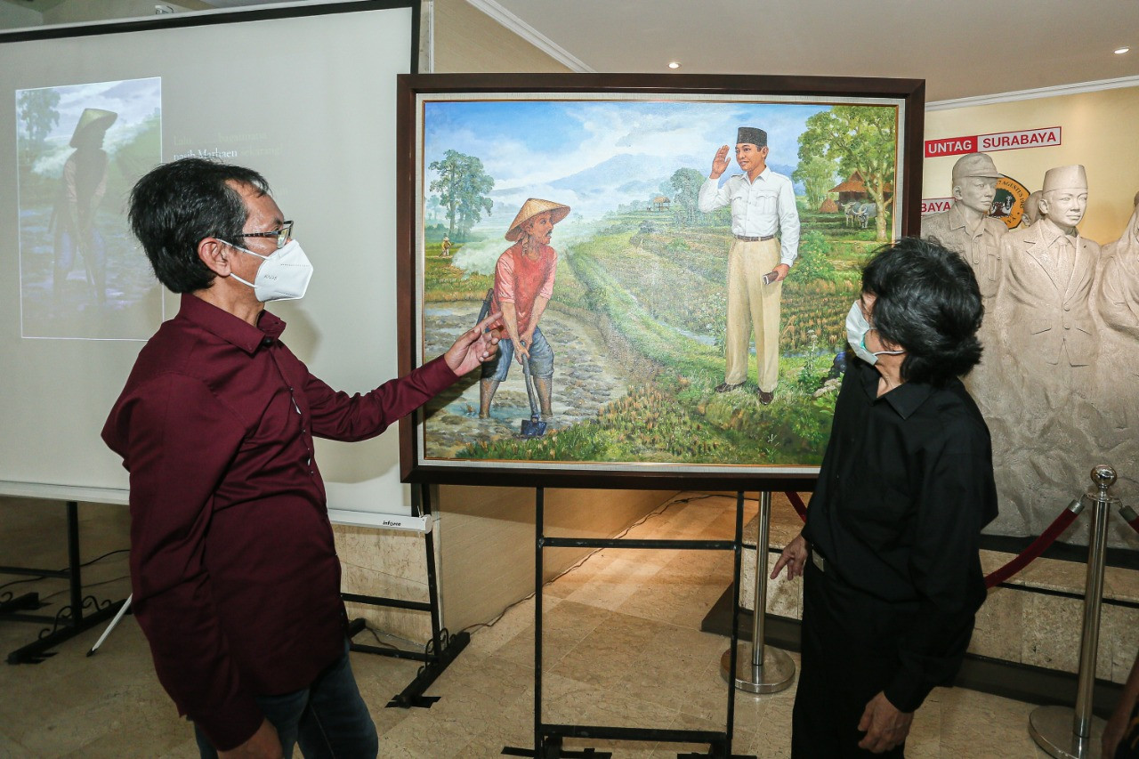 Ketua DPRD Kota Surabaya Adi Sutarwijono bersama tokoh Marhaenis, Yakobus Mayongpadang, di depan lukisan 'Pertemuan Bung Karno dengan Pak Marhen' karya pelukis Surabaya S. Pandji. (Foto: Alief Sambogo/Ngopibareng.id)