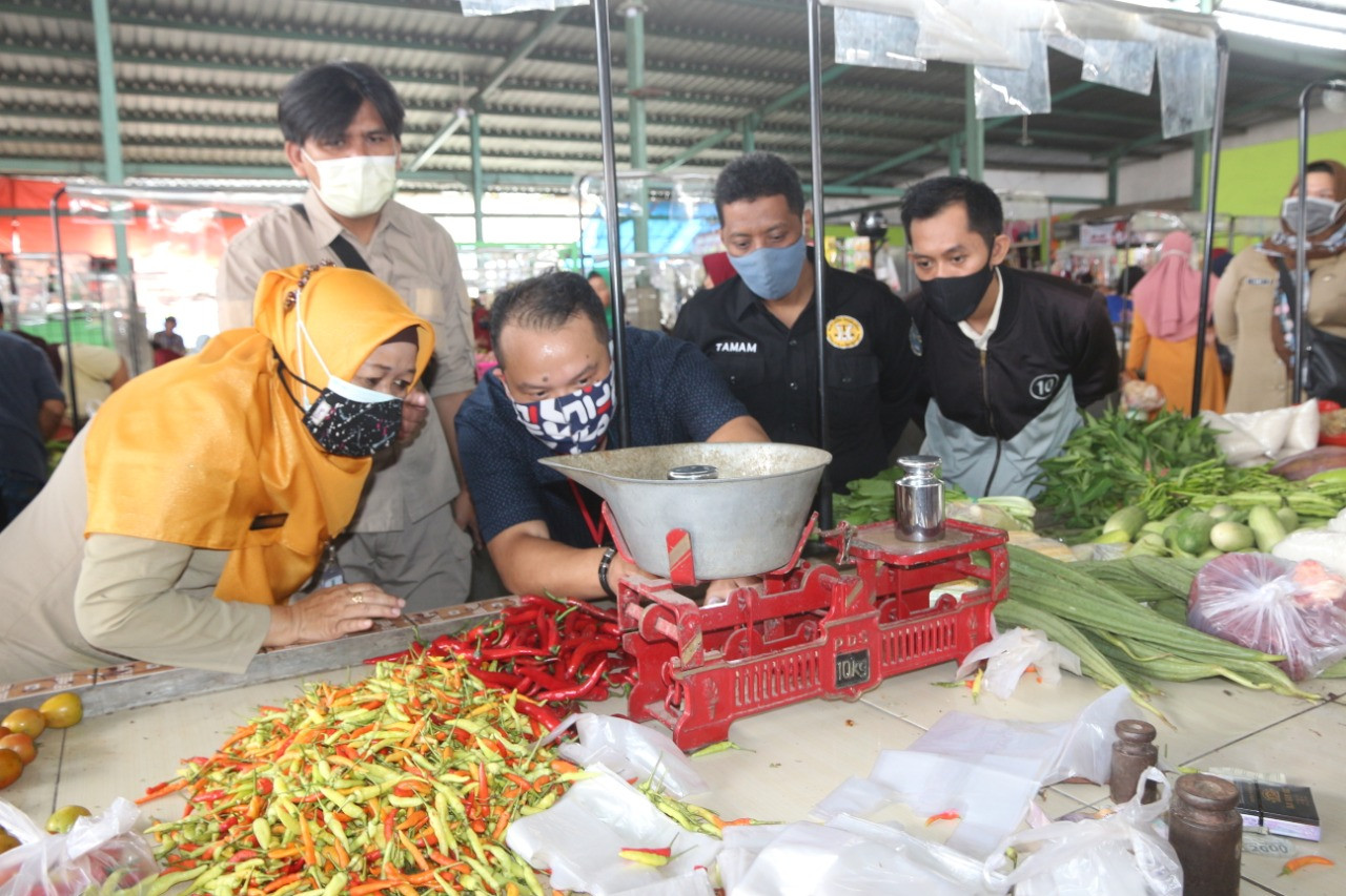 Petugas sedang mengecek timbangan di sebuah Pasar Kronong, Kecamatan Mayangan, Kota Probolinggo. (Foto: Ikhsan Mahmudi/Ngopibareng.id)