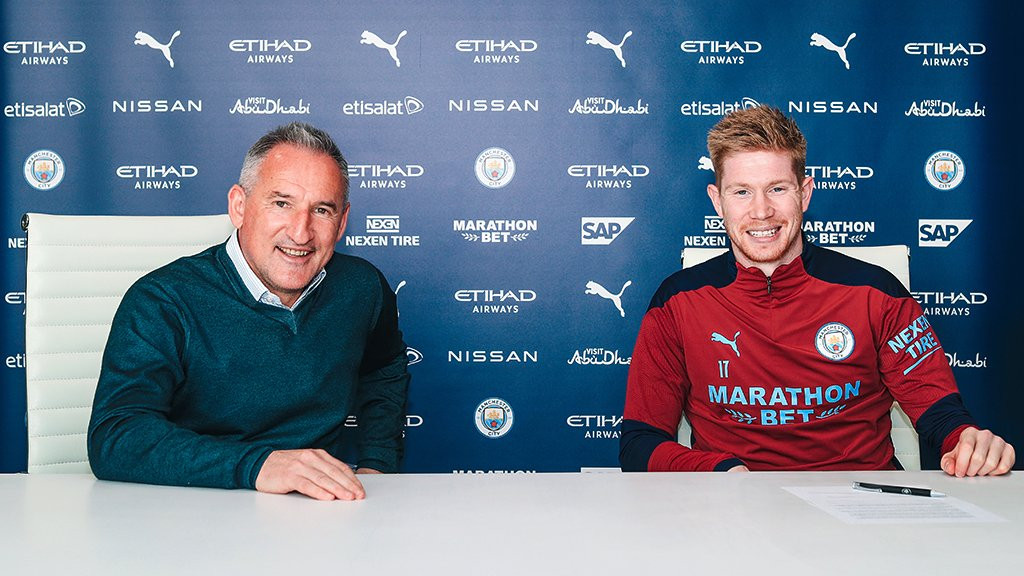 Didampingi direktur olahraga Manchester City Txiki Begiristain, Kevin de Bruyne menandatangani kontrak baru. (Foto: Twitter/@ManCity)