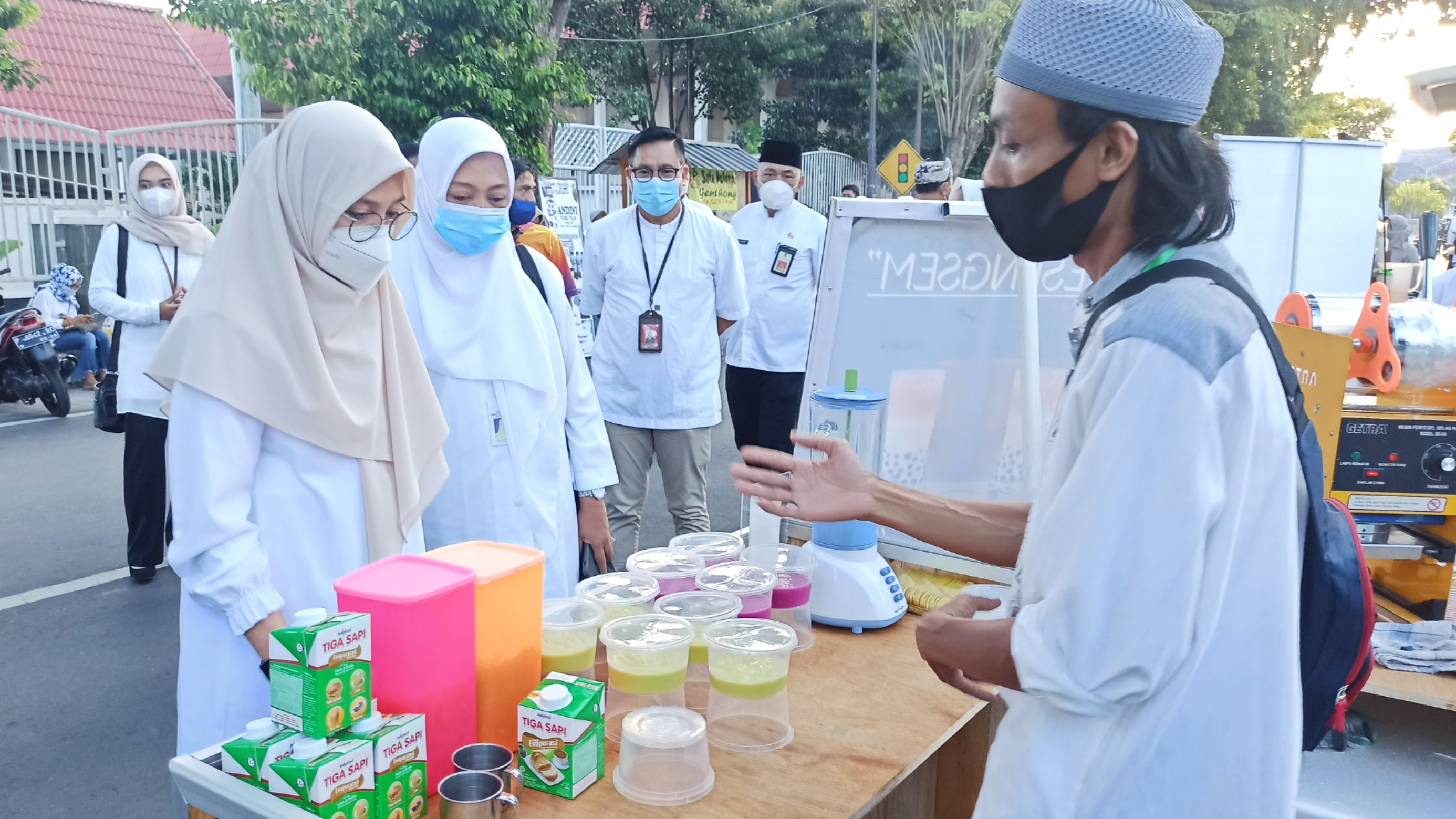 Bupati Banyuwangi Ipuk Fiestiandani didampingi Plt. Kepala Dinas Koperasi Usaha Mikro dan Perdagangan Banyuwangi Nanin Oktaviantie sedang berbincang dengan salah satu pelaku usaha UMKM yang menjual takjil Ramadhan (foto:Muh Hujaini/Ngopibareng.id)