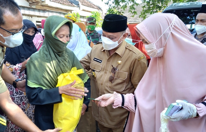 Bupati Situbondo H.Karna Suswandi didampingi istri Hj. Juma’ati Karna Suswandi membagikan sembako Ramadan kepada masyarakat kurang mampu. (Foto: Istimewa)