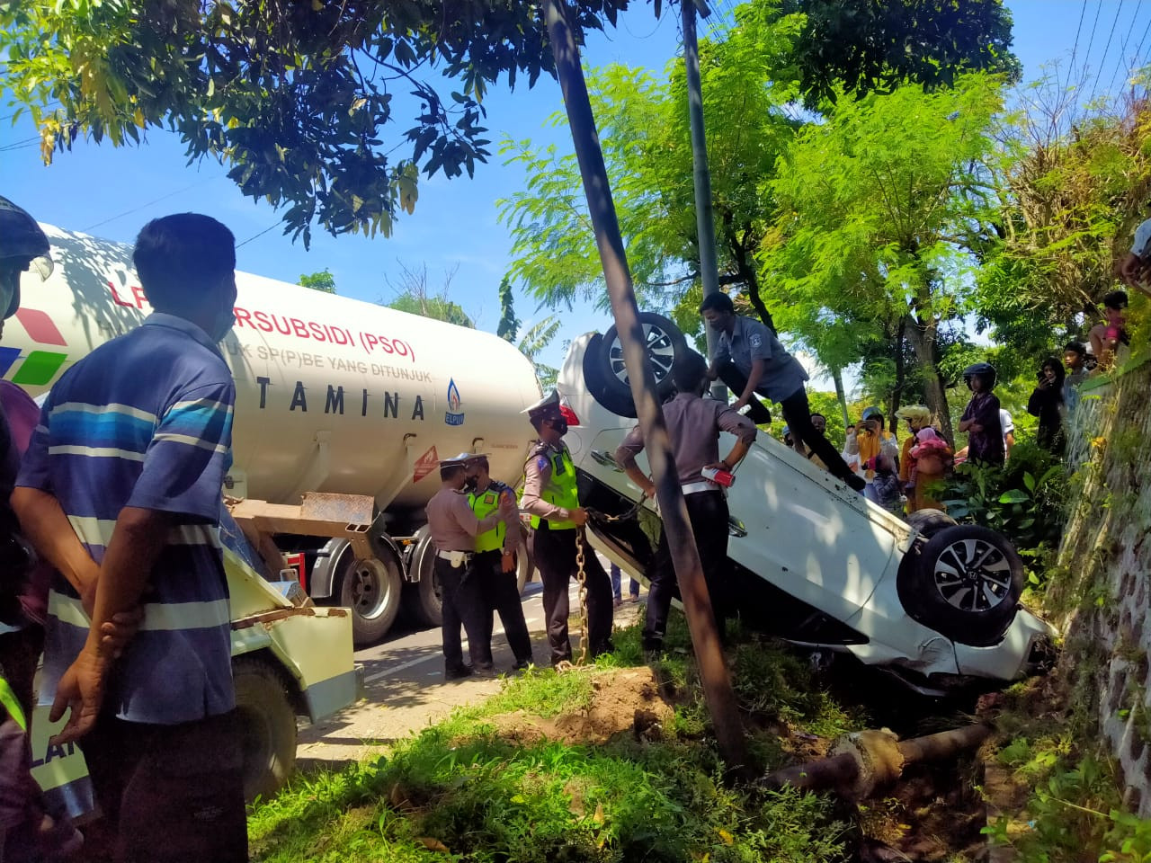 Anggota Satlantas Polres Jember hendak mengevakuasi Mobil Honda Brio yang terlibat kecelakaan (Foto:Rusdi/ngopibareng.id)