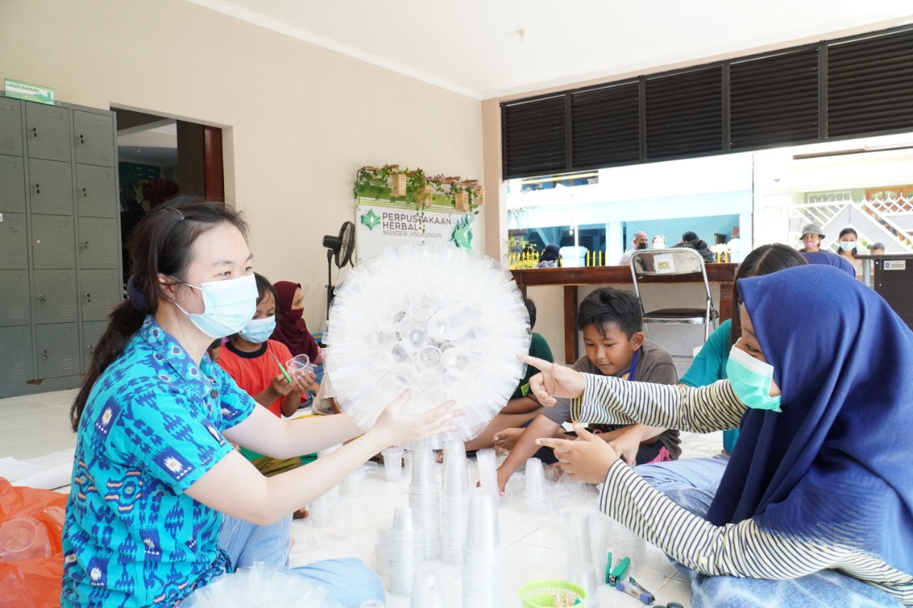 Dosen dan mahasiswa UK Petra saat menunjukan lampu yang terbuat dari bahan bekas pada warga. (Foto: istimewa)