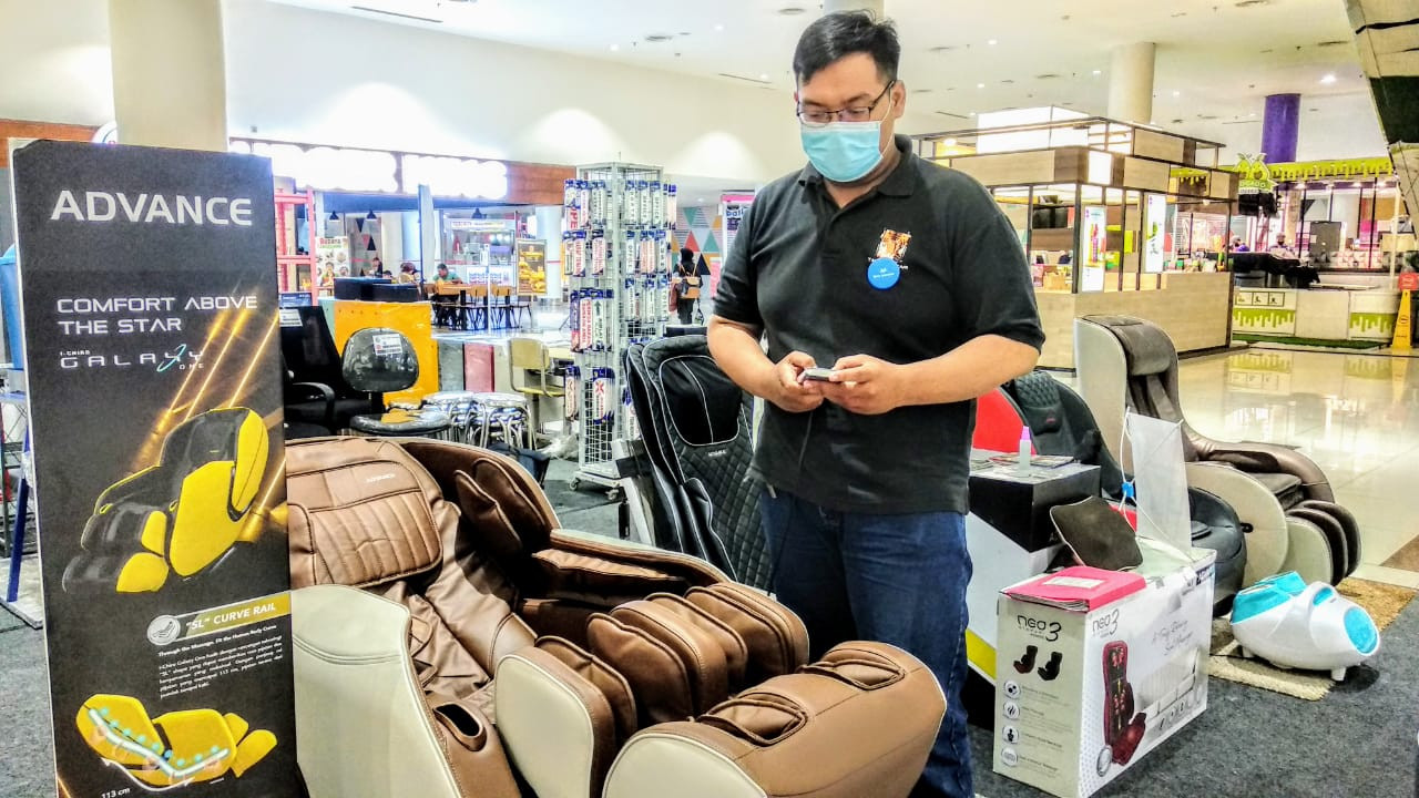 Ali Akbar, Sales Promotion Boy Gramedia Ciputra World Surabaya saat mendemokan fitur kursi pijat Ichiro Galaxy One (Foto: Mutqiyyah Rizqi/Ngopibareng.id)