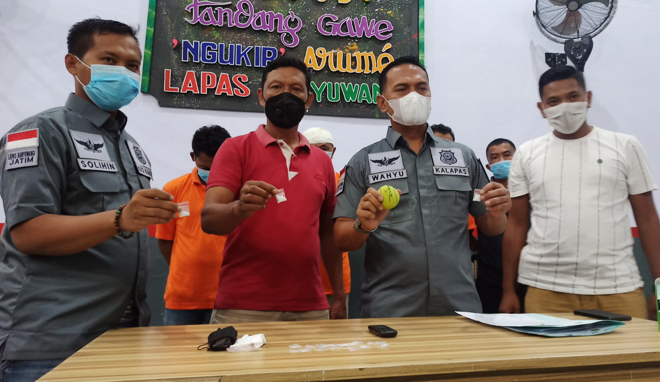 Kepala Lapas Kelas IIA Banyuwangi, Wahyu Indarto (dua dari kanan) bersama anggota Reserse Narkoba Polresta Banyuwangi, menunjukkan barang bukti narkoba jenis sabu-sabu yang diselundupkan melalui bola tenis yang dilemparkan ke dalam Lapas. (Foto: Muh Hujaini/Ngopibareng.id)