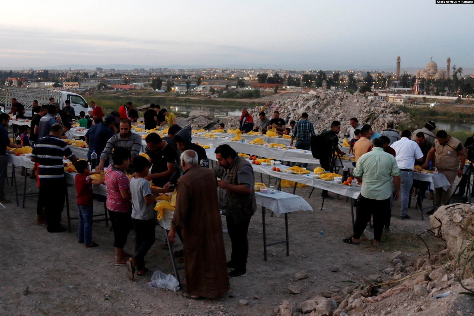 Orang-orang berkumpul untuk berbuka puasa selama bulan puasa Ramadhan, di Mosul, Irak, 15 April 2021. (Foto: reuters)