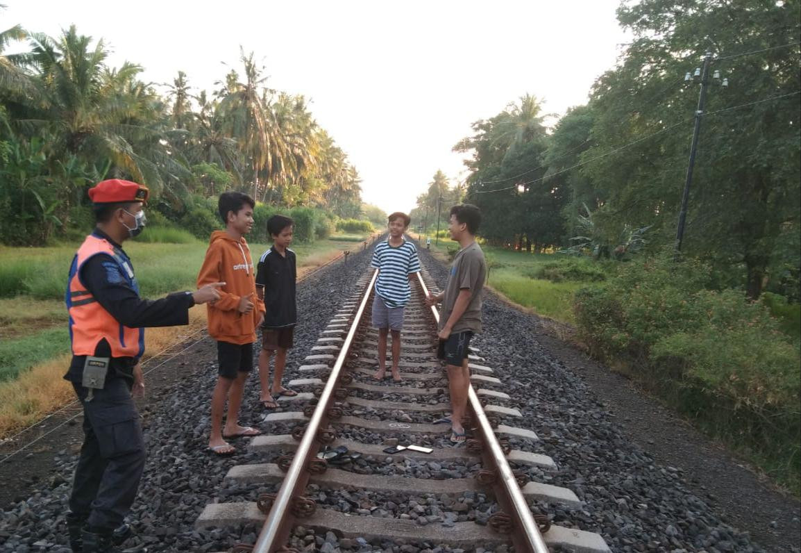 Petugas membubarkan masyarakat yang ngabuburit disekitar jalur rel KA (foto:istimewa)