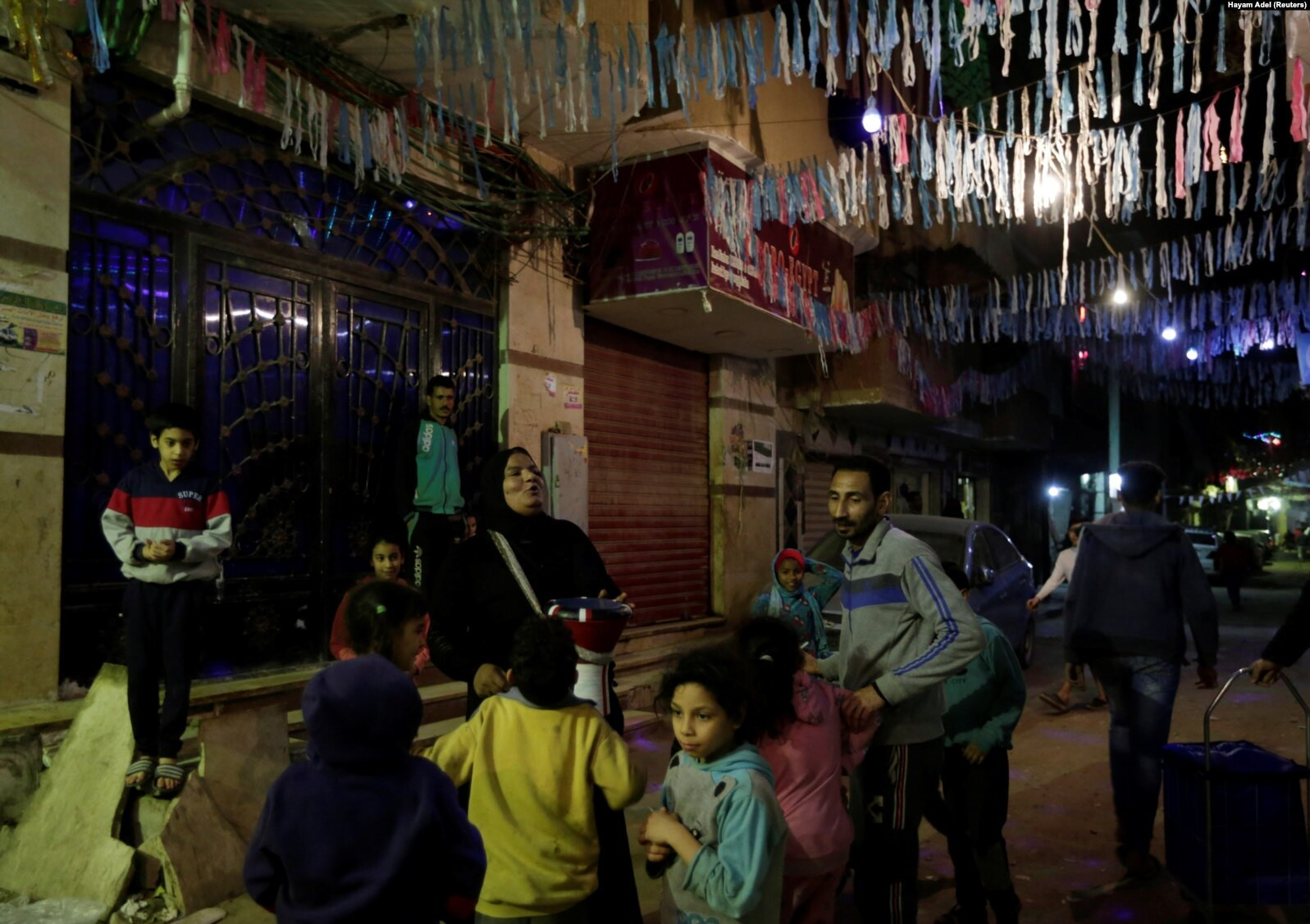 Hajah Dalal Abdelqader, seorang penabuh genderang (Mesaharati) berusia 46 tahun, menabuh genderang untuk membangunkan umat Islam untuk sahur sebelum mereka memulai puasa Ramadhan, di Maadi di Kairo, Mesir, 13 April 2021 (Foto: reuters)