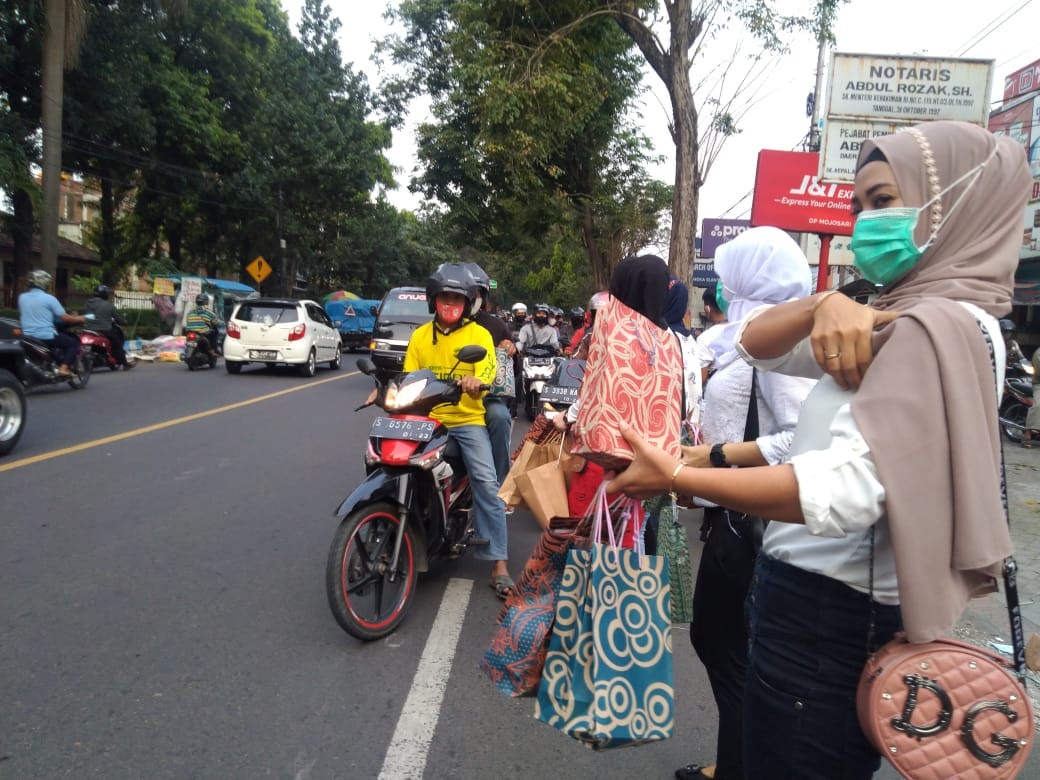 Para pemandu lagu di Mojokerto bagikan ribuan takjil kepada masyarakat yang melintas di wilayah Kecamatan Mojosari, Kabupaten Mojokerto. (Foto: Lukman/Ngopibareng.id)