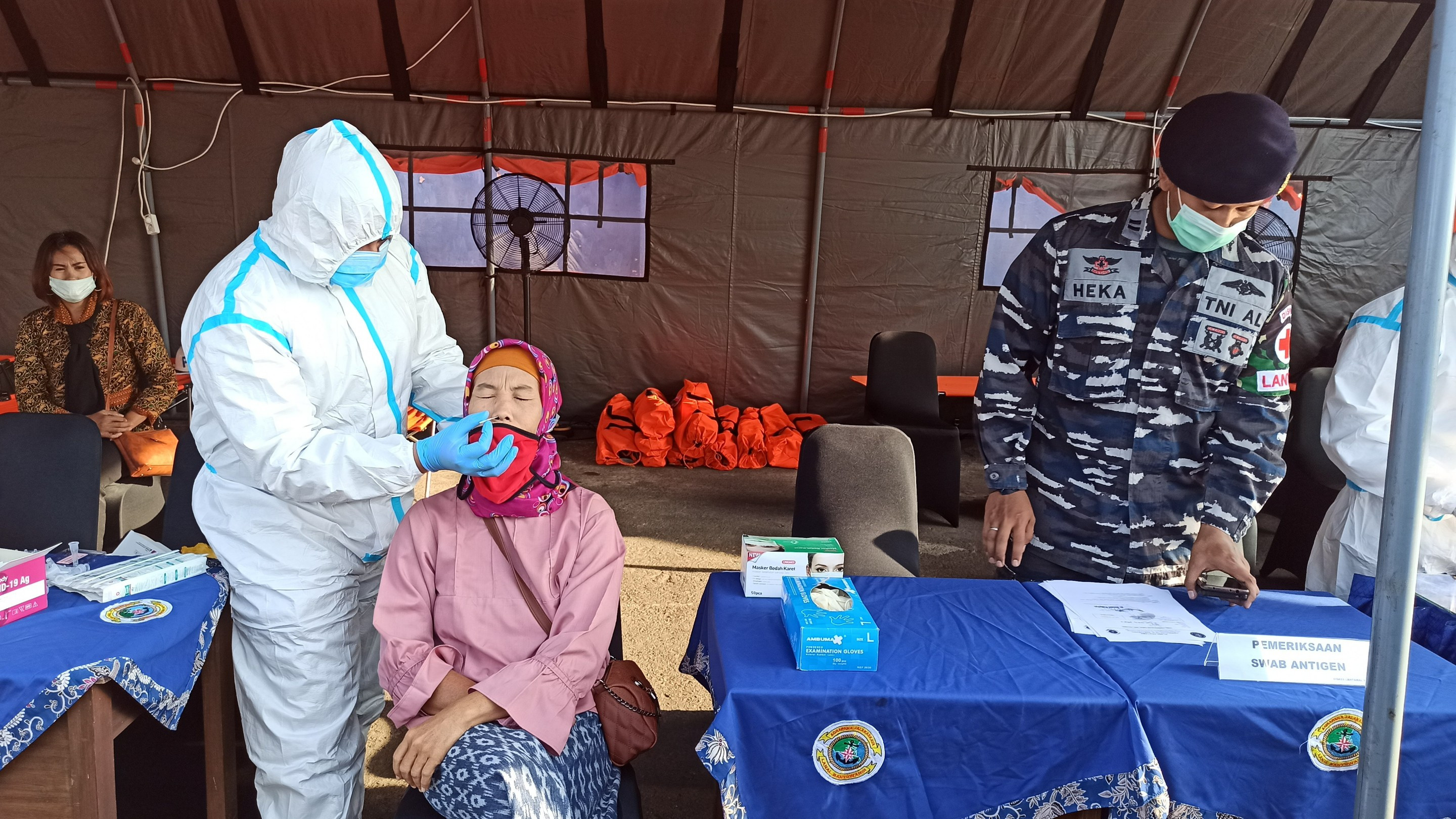 Salah seoran keluarga Kru KRI Nanggala 402 yang akan mengikuti upacara tabur bunga menjalani test swab antigen di posko yang ada di Pelabuhan Tanjungwangi, Banyuwangi (foto: Muh Hujaini/Ngopibareng.id)