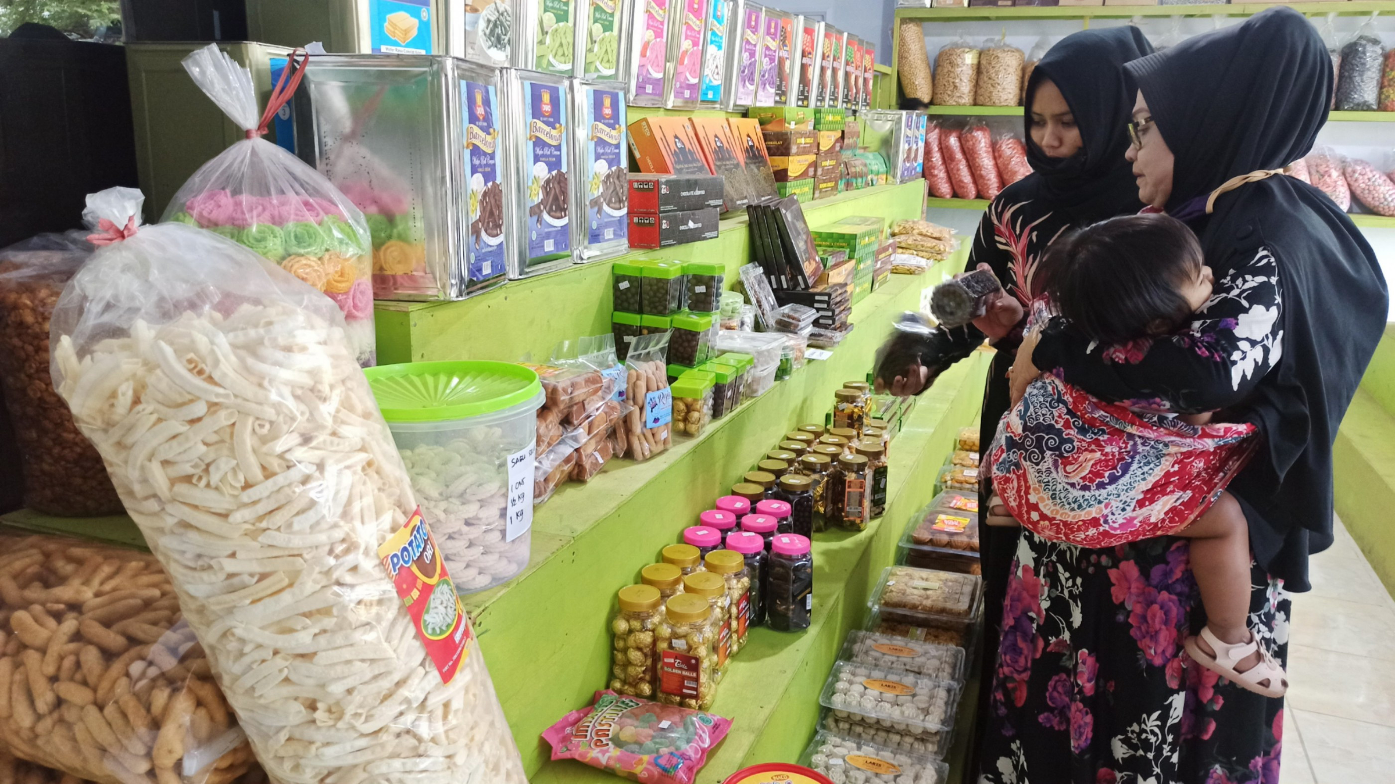 Beberapa ibu-ibu tampak memilih kue lebaran di salah satu toko penjual kue lebaran di Banyuwangi (foto:Muh Hujaini/Ngopibareng.id)