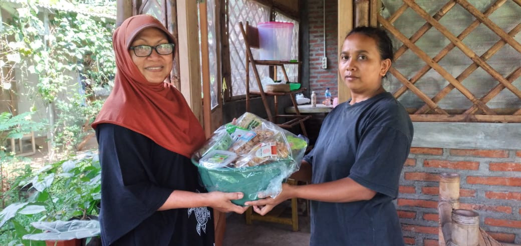 Wina Bojonegoro (kiri) membagikan parsel ke warga Semambung, Pasuruan, Jawa Timur. (Foto: Dok. Wina Bojonegoro/Ngopibareng.id)