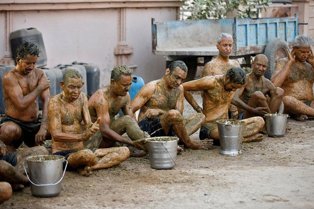 Warga India mandi kotoran sapi untuk mencegah virus corona. (Foto: Reuters)