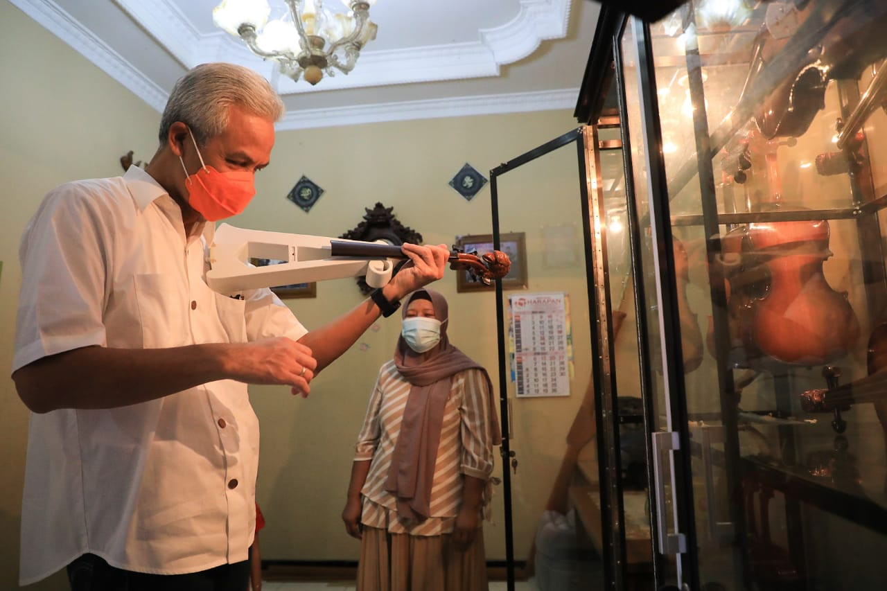 Ganjar melihat biola dari bambu hasil kerajinan tangan Mbah Min. (Foto: Dok Jateng)