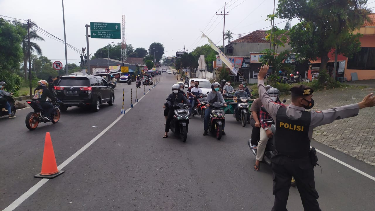 Petugas mengatur arus lalu lintas di simpang tiga Kecamatan Pacet.(Foto: Deni Lukmantara/Ngopibareng.id)