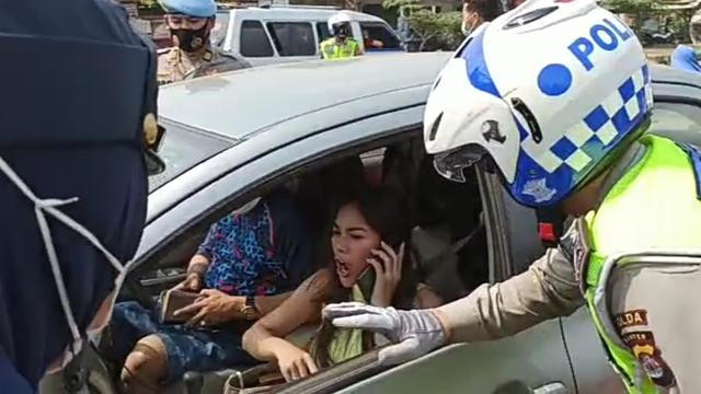 Perempuan berkaos hijau muda u can see ini tak bisa membendung amarahnya karena dipaksa putar balik petugas saat menuju Anyer. (Foto: Istimewa)