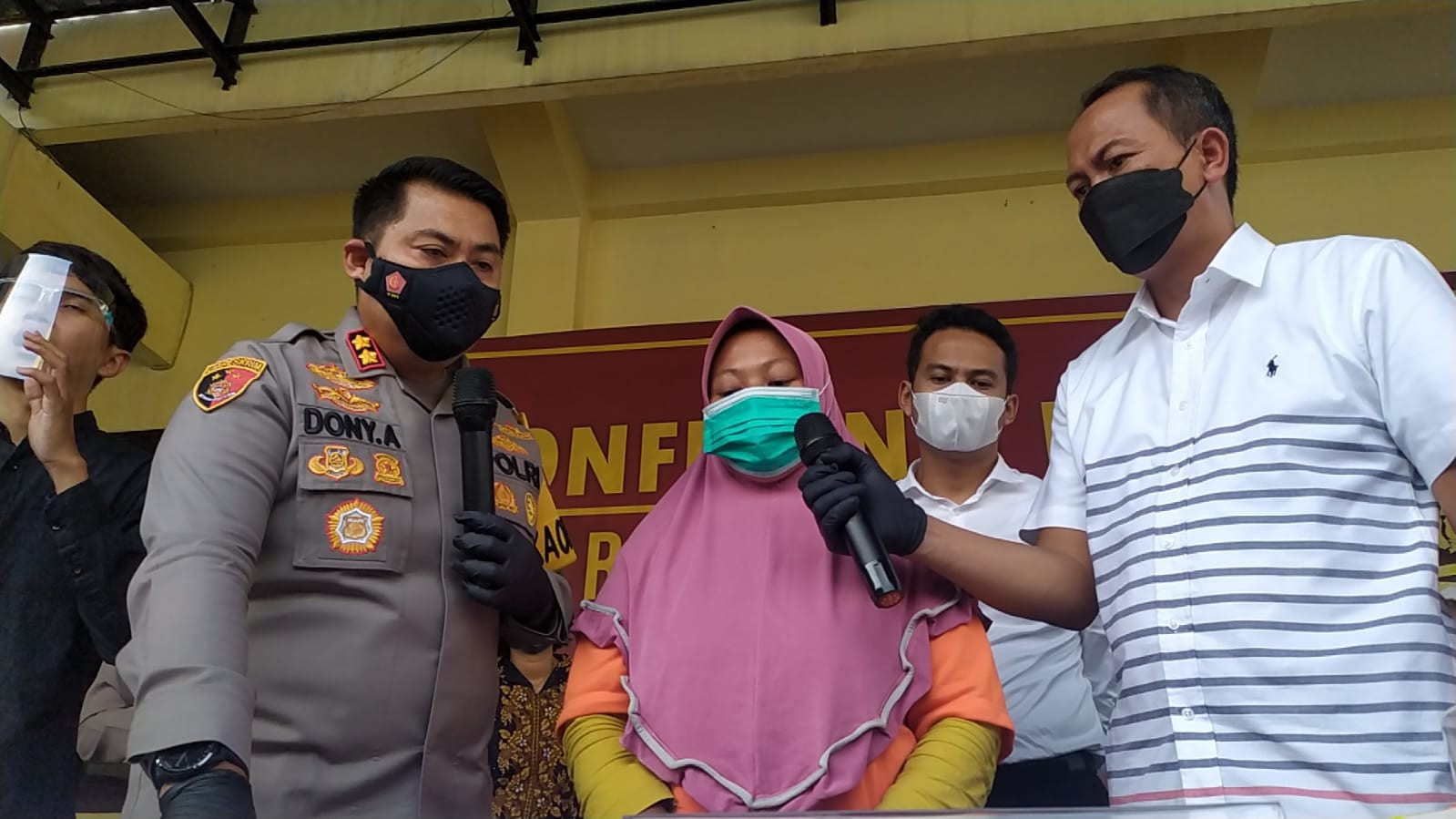 Tarmiati alias Mia, 42 tahun, bos arisan lebaran (tengah) saat diinterogasi polisi dalam konferensi pers di Mapolres Mojokerto.(Foto: Deni Lukmantara/Ngopibareng.id)