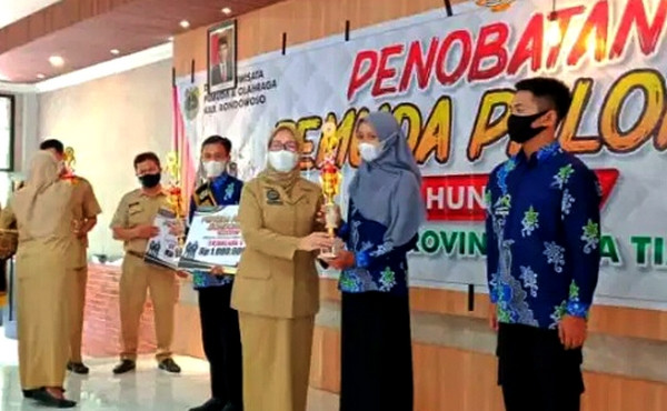 Plt. Kepala Disparpora Bondowoso Retno Wulandari saat menyerahkan trofi kepada 12 Pemuda Pelopor Bondowoso 2021. (Foto: Disparora/Ngopibareng.id)