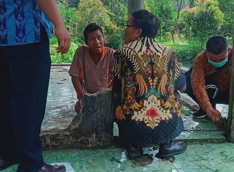 Salah satu petugas melepas rantai yang dipakai memasung Iwan di salah satu padepokan terapi ODGJ. (Foto: Fendhy Plesmana/Ngopibareng.id)