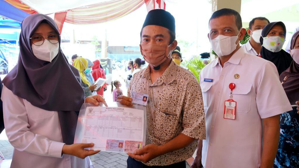 Bupati Banyuwangi Ipuk Fiestiandani menyerahkan dokumen kependudukan warga Penghayat Kepercayaan saat ngantor di Desa Singolatren (foto:istimewa)