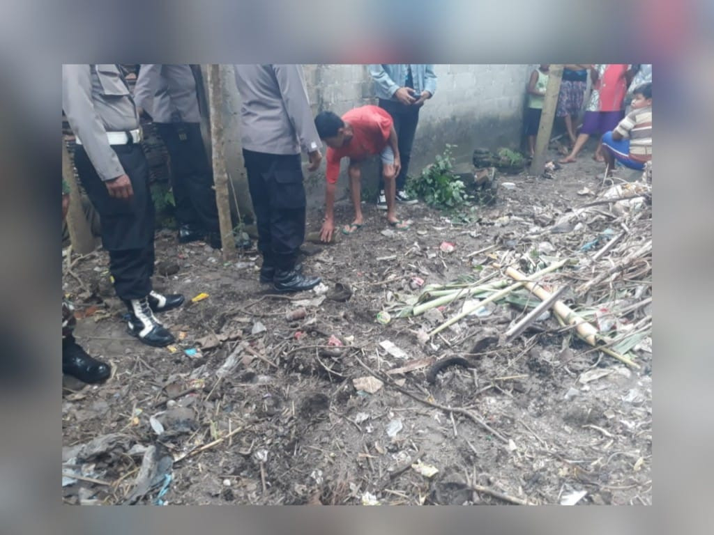 Suradi berkaos merah menunjukkan tempat penemuan bayi perempuan yang dibuang hanya beralaskan daun pisang. Lokasinya berada di halaman belakang sebuah rumah kosong di Desa Ngoran Kecamatan Nglegok Kabupaten Blitar. (Foto: Choirul Anam/Ngopibaren.id)