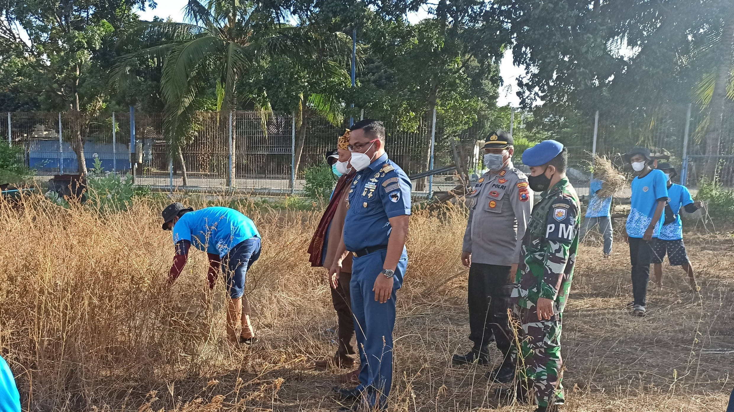 Warga sekitar pelabuhan melaksanakan program padat karya membersihkan rumput di area Pelabuhan Tanjungwangi, Banyuwangi (Foto: Muh Hujaini/Ngopibareng.id)