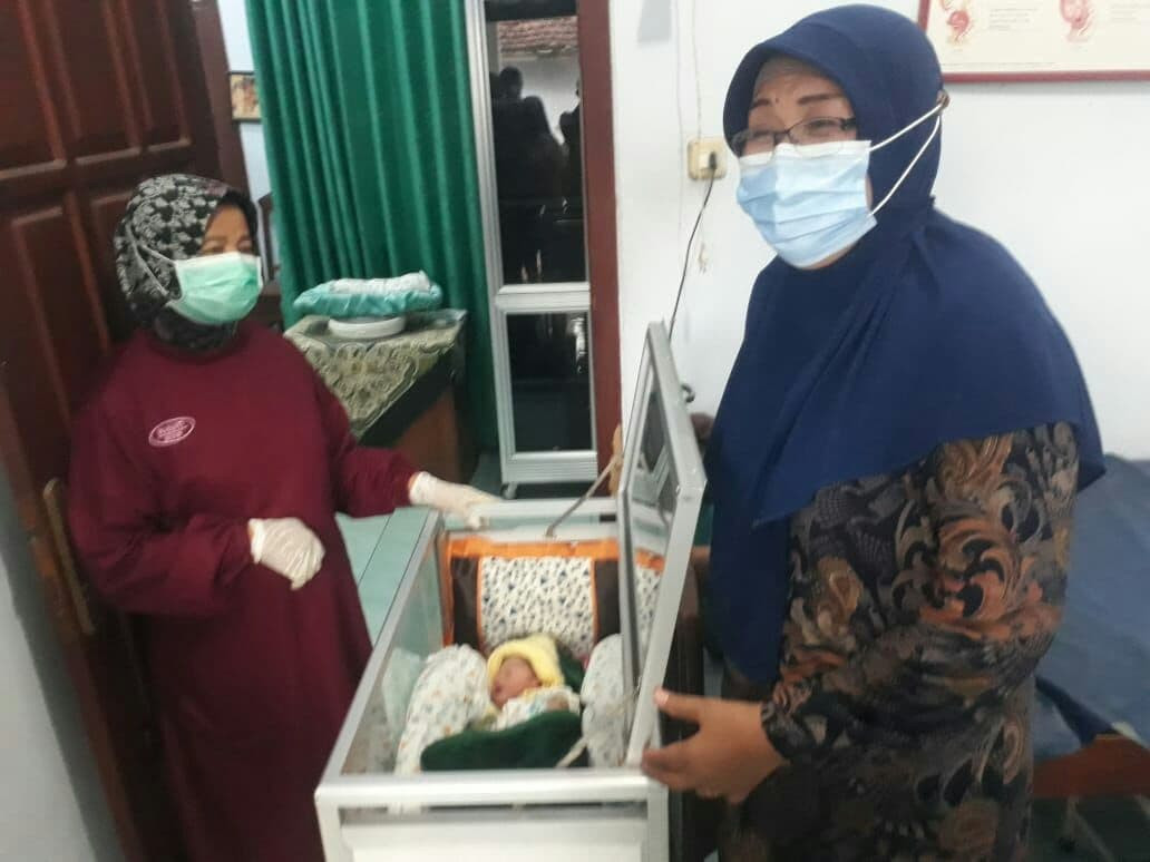 Wasiti, bidan desa Ngoran kecamatan Nglegok, kabupaten Blitar dan Marsiati orang tua keluarga yang akan merawat bayi perempuan yang ditemukan, hari Jumat, 4 Juni 2021. (Foto: Choirul Anam/Ngopibareng.id)