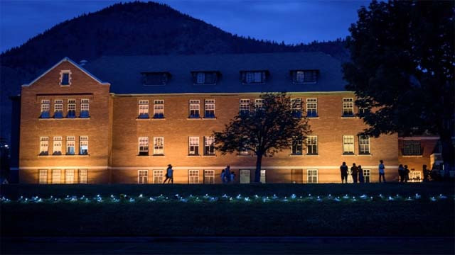 Orang-orang berjalan melewati bekas sekolah di Kamloops, British Columbia, Kanada, setelah ditemukan  215 jenazah anak-anak terkubur di area ini. [Foto:Reuters]