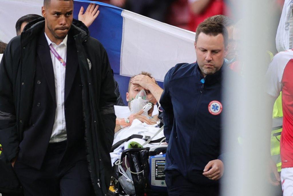 Bendera Finlandia menutupi bagian belakang Christian Eriksen ketika dibawa menuju ke ambulan.