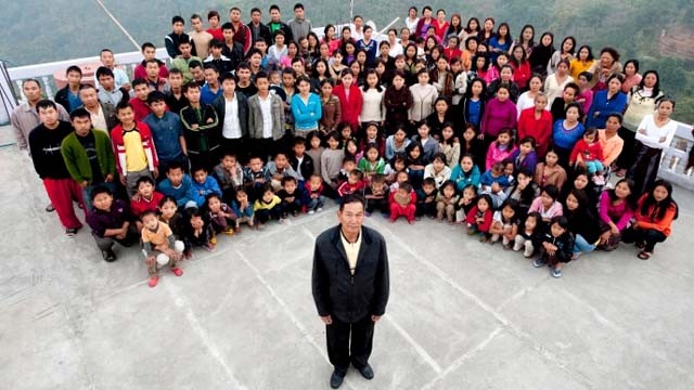 Ziona Chana (depan) sebelum meninggal, foto bersama keluarga besarnya di Baktawang, Mizoram, India. Ziona Chana punya 38 istri, 89 anak dan 33 cucu. (Richard Grange/Barcroft India/Getty Images)