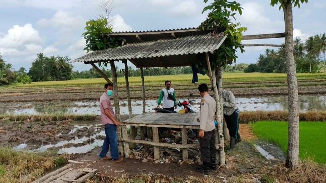 Petugas Polsek Kabat melakukan olah TKP di lokasi penemuan bayi. (Foto: Istimewa)