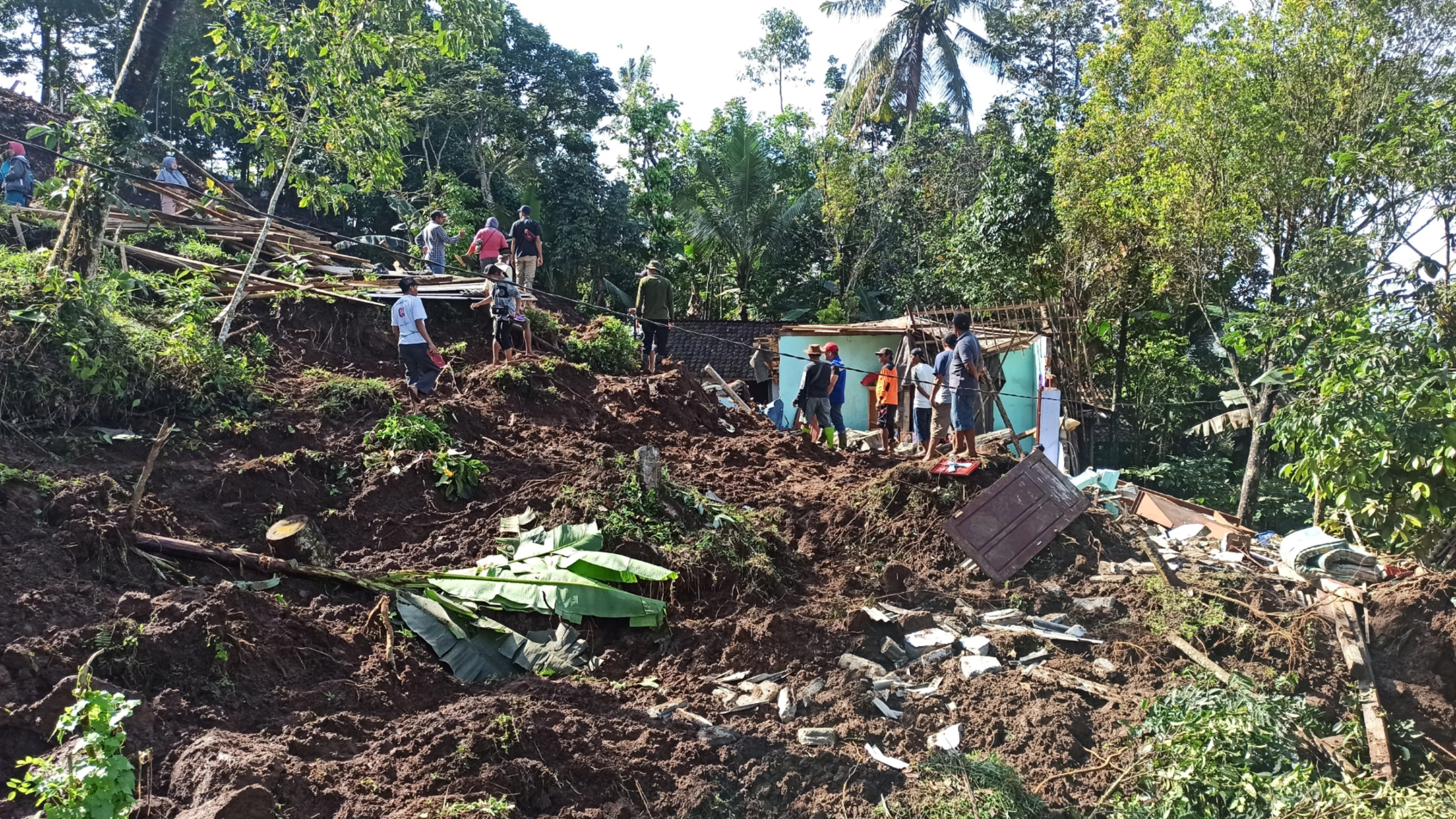 Tiga rumah yang tertimpa longsor rata dengan tanah. Hanya tampak puing-puing rumah saja (foto:Muh Hujaini/Ngopibareng.id)