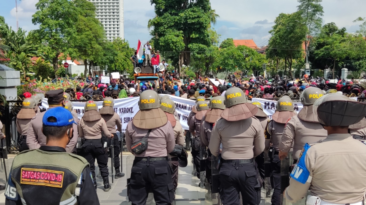 Aparat mengamankan aksi demonstrasi yang dilakukan sekelompok warga penolak swab dan penyekatan di Suramadu, di Baliakota Surabaya, Senin 21 Juni 2021. (Foto: Fariz Yarbo/Ngopibareng.id)