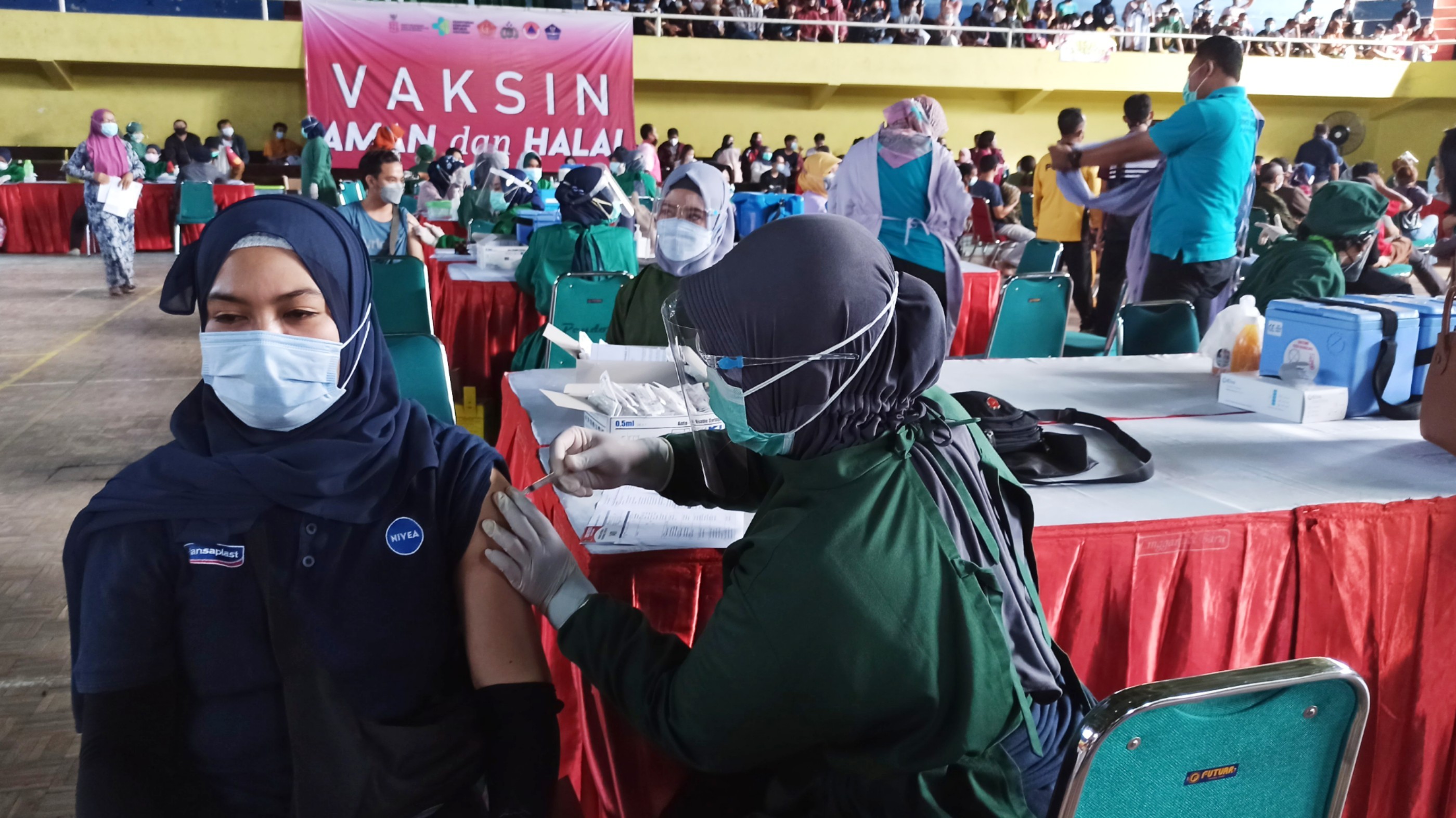 Salah seorang warga mengikuti vaksinasi massal yang dilakukan di GOR Tawangalun Banyuwangi, Jawa Timur. (Foto: Muh Hujaini/Ngopibareng.id)