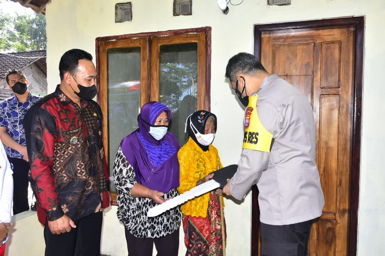 Kapolres Blitar menyerahkan kunci rumah secara simbolis kepada Mbah Tukinem. (Foto: Choirul Anam/Ngopibareng.id)