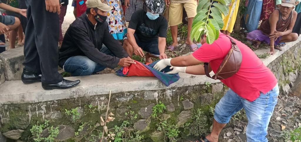 Proses evakuasi mayat bayi yang dilakukan polisi dibantu warga. (Foto: Istimewa)