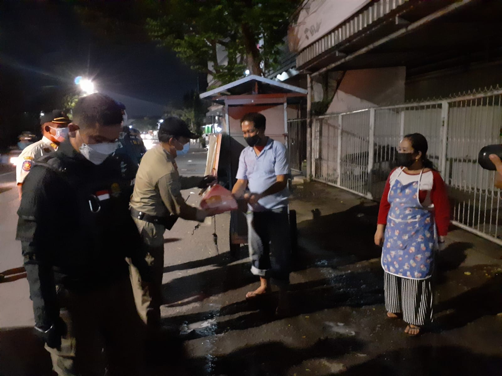 Petugas Satpol PP Surabaya memberikan bantuan paket sembako kepada pedagang kaki lima dalam penertiban di massa PPKM Darurat. (Foto: Fariz Yarbo/Ngopibareng.id)