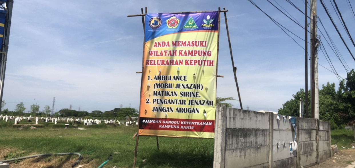 Banner yang dipasang warga Keputih karena terganggu suara sirine ambulans. (Foto: Andhi Dwi/Ngopibareng.id)