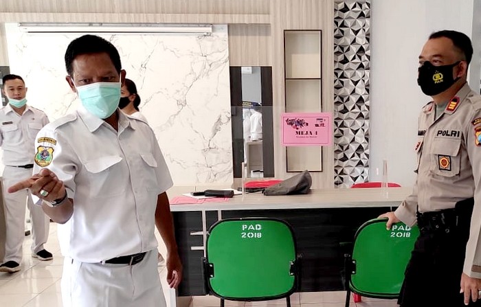 Ketua IDI Bondowoso dr.Slamet Santoso (kiri) menjelaskan para dokter membantu pemkab dalam penanganan Covid-19 dengan membuka layanan konsultasi medis gratis online lewat WA kepada pasien isoman. (Foto: Guido Saphan/Ngopibareng.id)