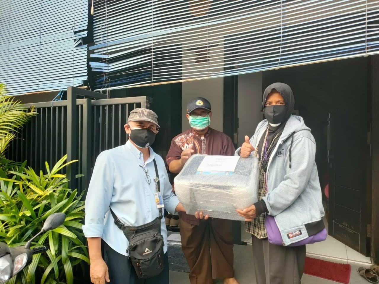 Perwakilan UK Petra (Kiri) saat memberikan paket bantuan pada perwakilan LPKM Siwalankerto. (Foto: istimewa)