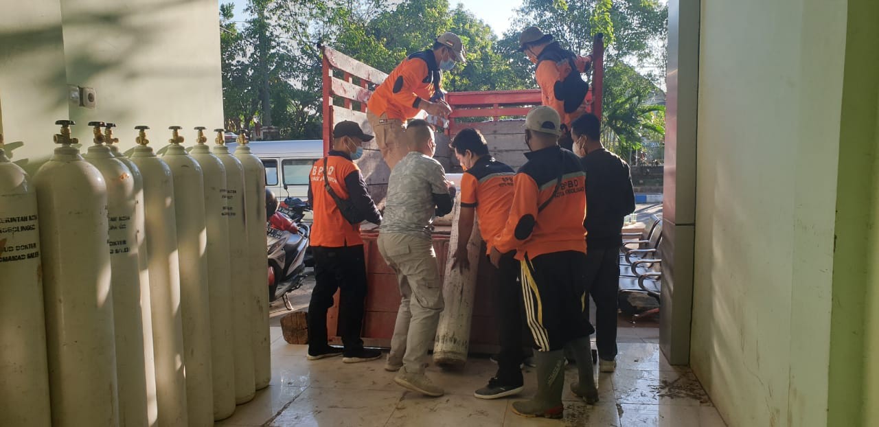 Petugas BPBD Kota Probolinggo menurunkan tabung oksigen untuk RSUD dr. Mohamad Saleh. (Foto: Ikhsan Mahmudi/Ngopibareng.id)