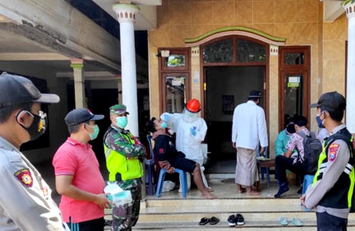 Satgas Covid-19 dengan kawalan TNI-Polri melakukan tracing dan testing terhadap warga terilbat aksi perebutan dan pembakaran peti jenazah Covid-19 di Desa Kemirian Kecamatan Tamanan. (foto: istimewa)