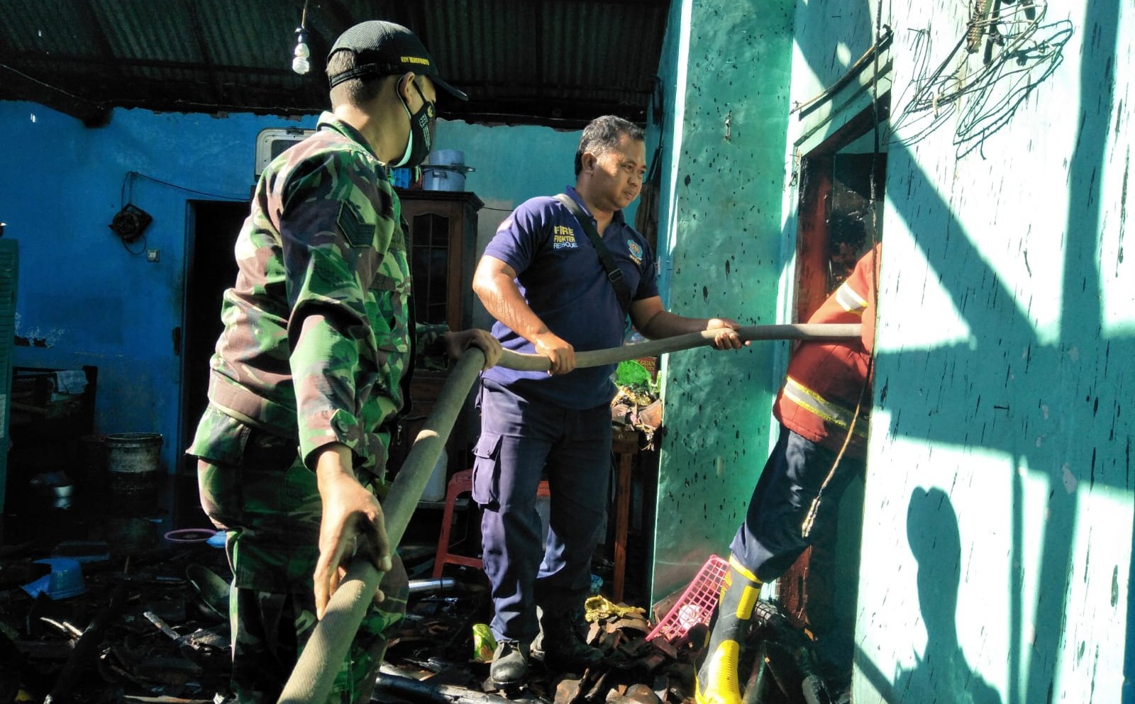 Petugas berusaha memadamkan kebakaran yang menimpa rumah Ponijan (foto: istimewa)