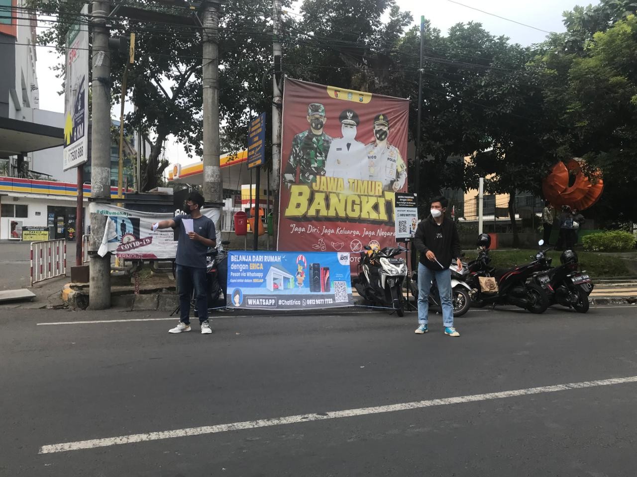 Sejumlah sales iBox saat membagikan brosur handphone kepada pengendara di Jalan Kawi, Kota Malang, Jawa Timur. (Foto: Lalu Theo/Ngopibareng.id)