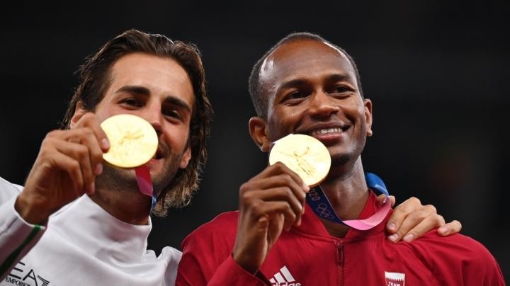 Atlet Italia, Gianmarco Tamberi dan atlet Qatar, Mutaz Essa Barshim menunjukkan medali emas mereka. (Foto: REUTERS)