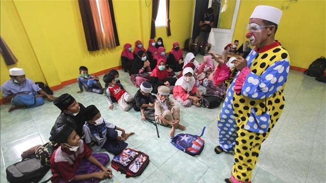 Yahya Edward Hendrawan, 38, mengajar Al-Quran bagi anak-anak yatim piatu di Yayasan An-Nur Darussalam, Tangerang, Provinsi Banten. Yahya yakin  pengajaran dengan kostum badut lebih efektif agar anak-anak menjadi bersemangat. (Foto: Eko Siswono/Anadolu Agency)