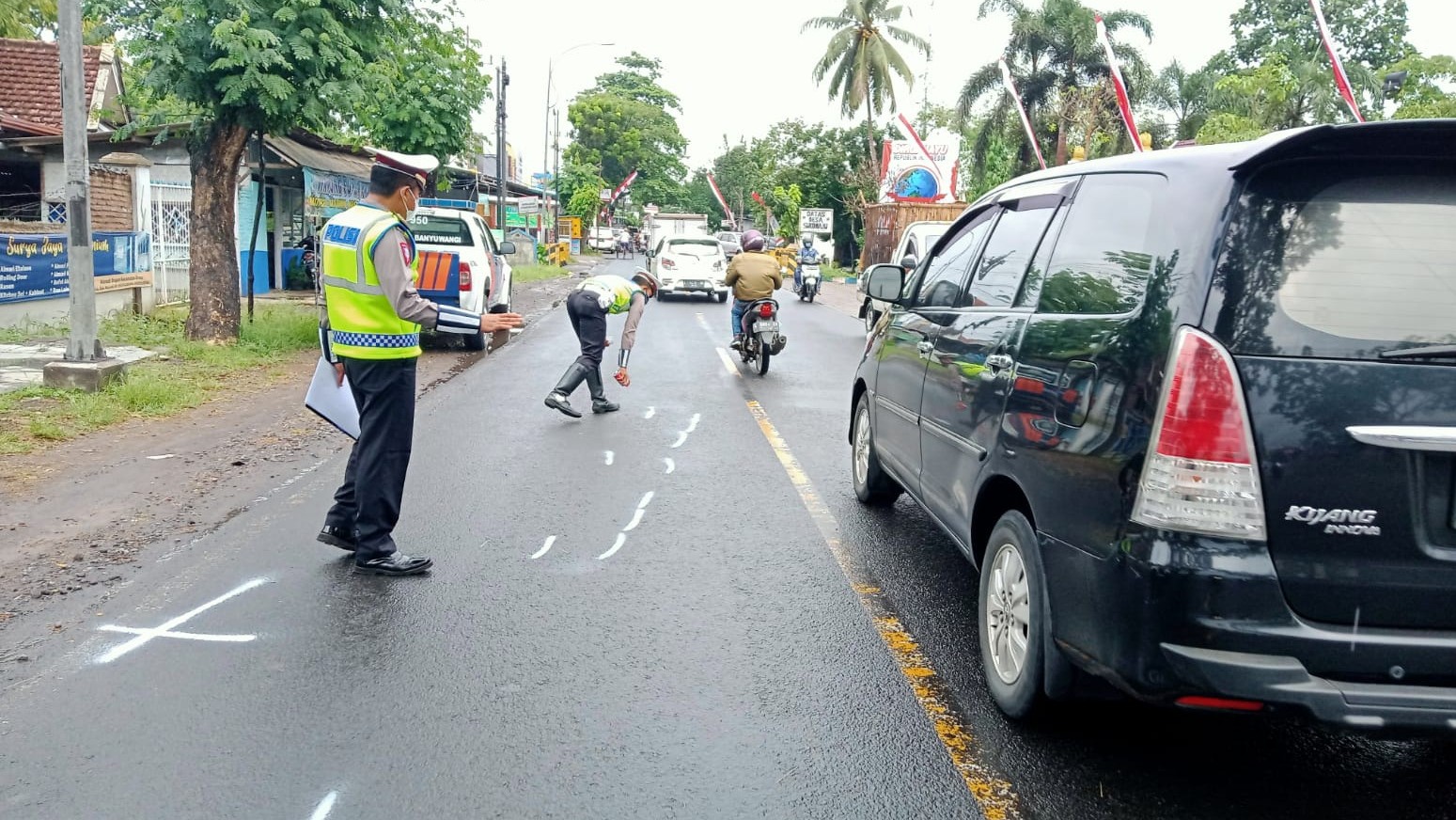 Petugas Unit Kecelakaan Satlantas Polresta Banyuwangi melakuian olah TKP kecelakaan maut yang merenggut nyawa pasangan suami istri (foto:istimewa)