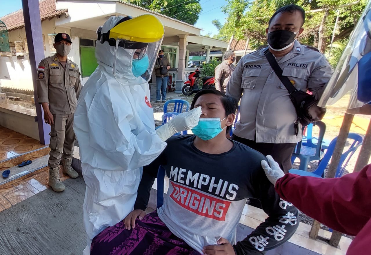 Salah seorang warga Tigasan Wetan, Kecamatan Leces, Kabupaten Probolinggo sedang menjalani tes swab. (Foto: Ikhsan Mahmudi/Ngopibareng.id)