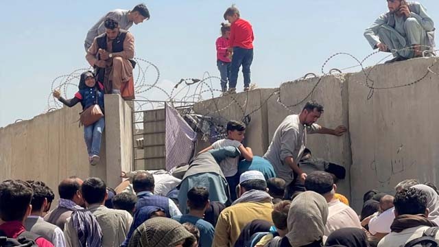 Warga berebut naik ke pagar untuk masuk ke kawasan Bandara Internasional Hamid Karzai di Kabul. Mereka berharap dapat segera meninggal Afghanistan setelah dikuasai Taliban. (Foto:Reuters/Al Jazeera)